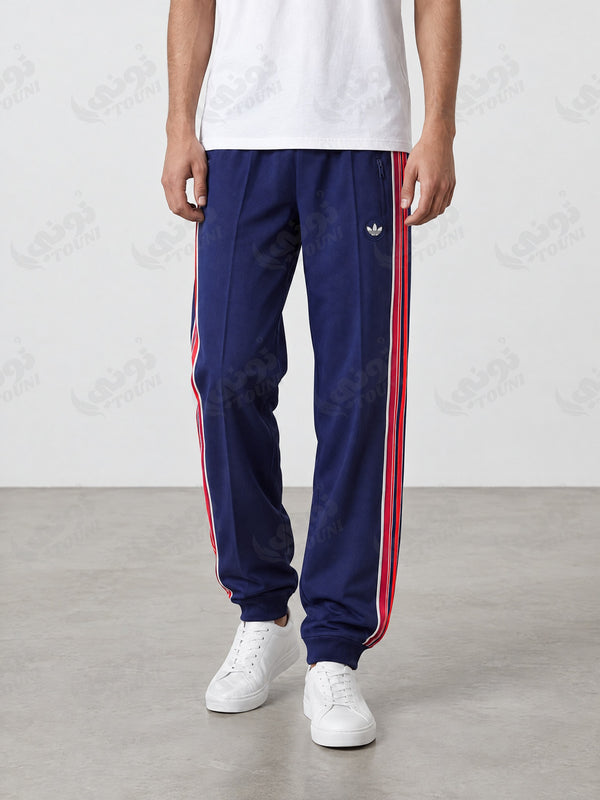 Pantalon de survêtement bleu marine bandes rouges et blanches, porté